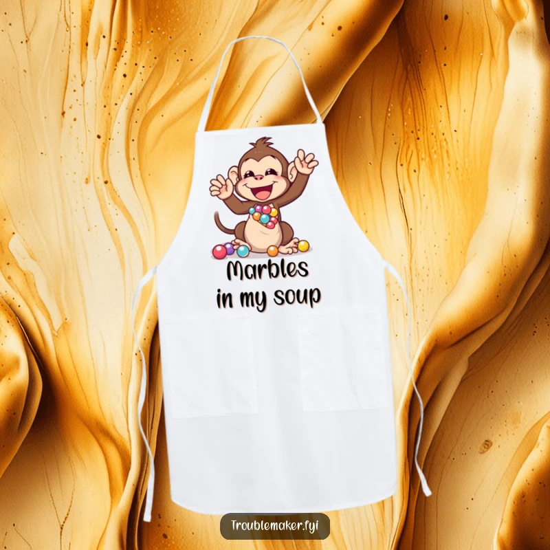 Funny apron showing a monkey character gleefully shaking a bag full of marbles, perfect for kitchen fun and protecting clothes.
