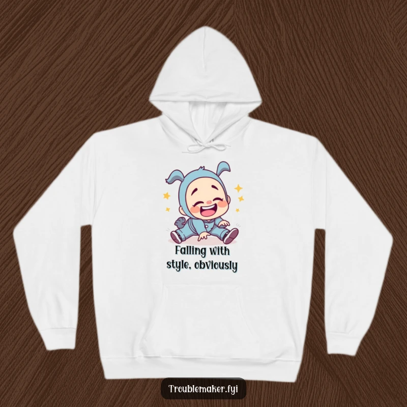 Funny troublemaker character tripping with a gleeful silly grin, depicted on a cozy hoodie, perfect for embracing life's unexpected stumbles.